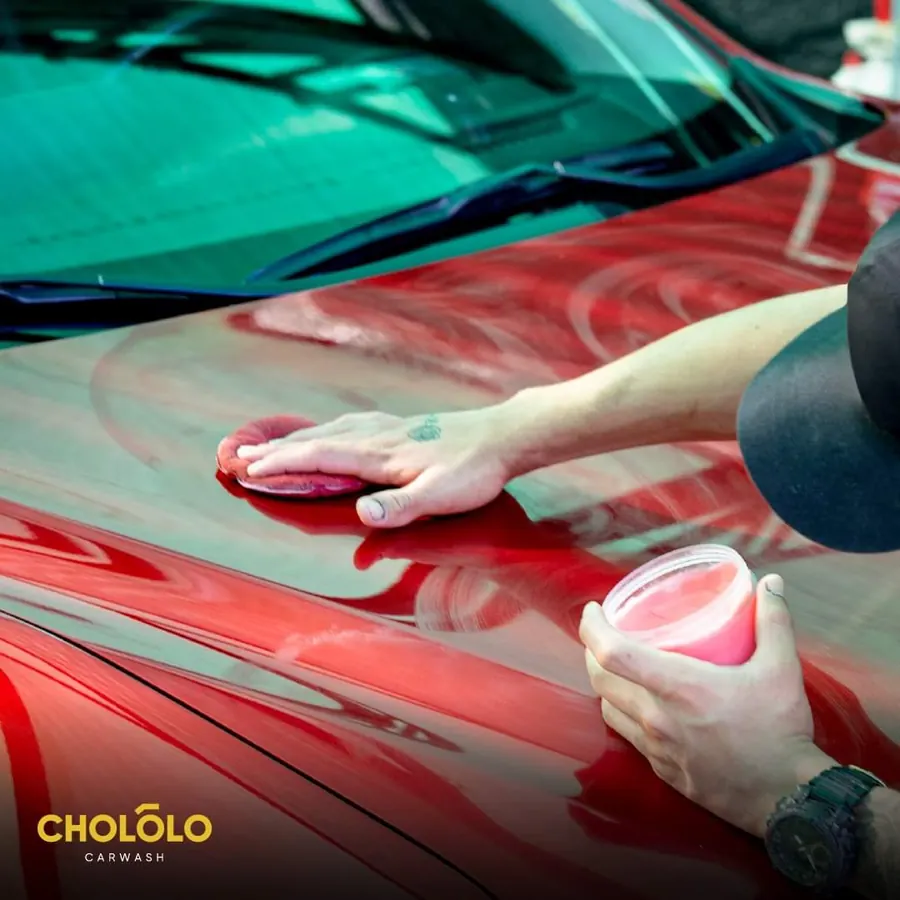 Encerado a mano sobre un capó rojo